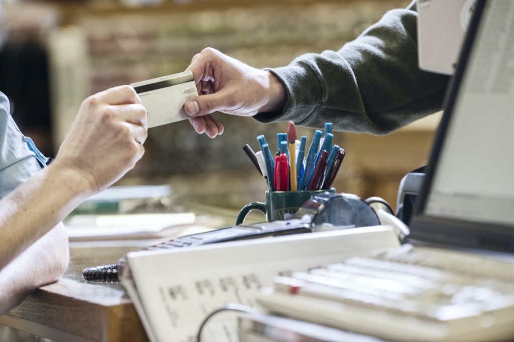 Closeup of hands exchanging a credit card during a retail sale